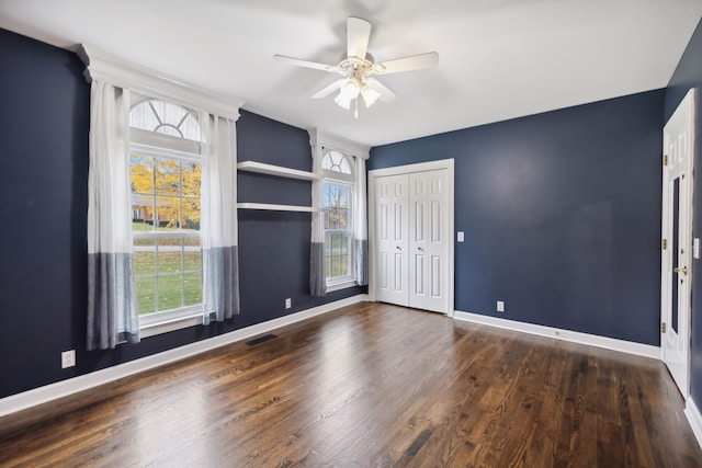 unfurnished room with ceiling fan and dark hardwood / wood-style flooring