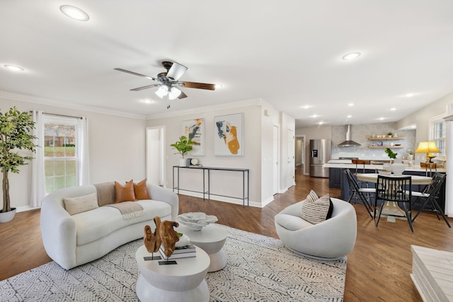 living room featuring light wood-type flooring, ceiling fan, and crown molding