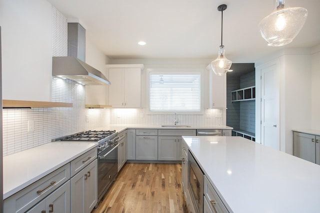 kitchen featuring appliances with stainless steel finishes, tasteful backsplash, sink, light hardwood / wood-style flooring, and gray cabinets