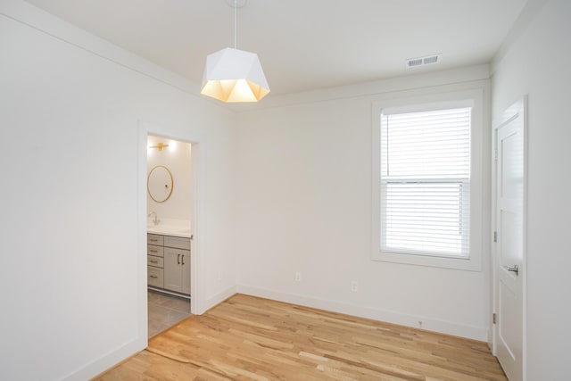 spare room featuring a wealth of natural light and light wood-type flooring