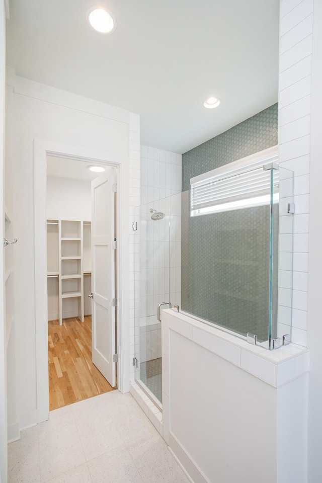 bathroom with hardwood / wood-style floors and an enclosed shower