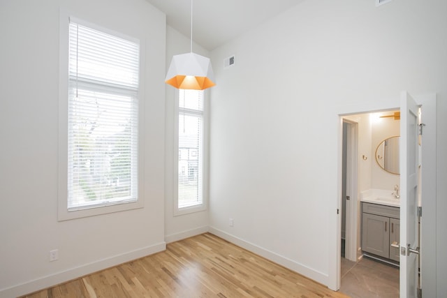 unfurnished dining area with sink and light hardwood / wood-style flooring