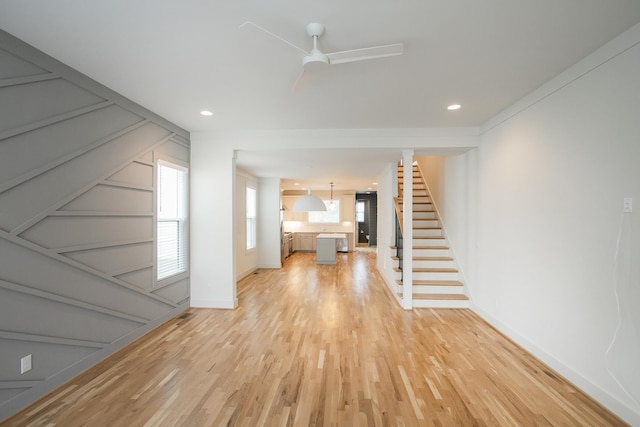 unfurnished living room with ceiling fan and light hardwood / wood-style floors