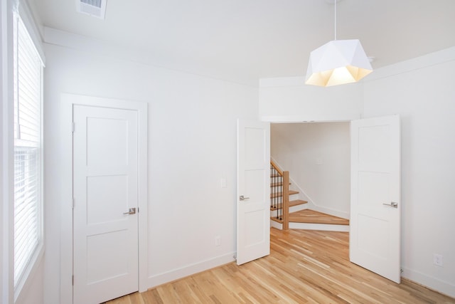 unfurnished room featuring wood-type flooring and a healthy amount of sunlight