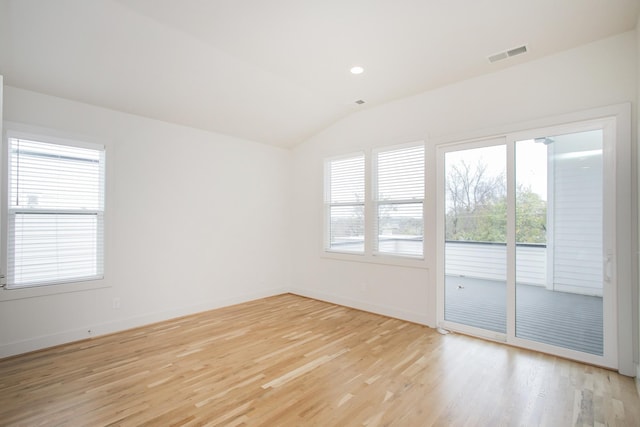 empty room featuring light wood-type flooring and vaulted ceiling