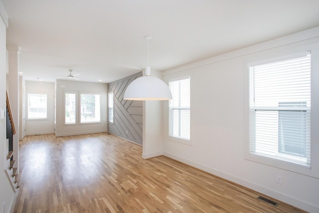 unfurnished living room featuring ceiling fan and light hardwood / wood-style flooring