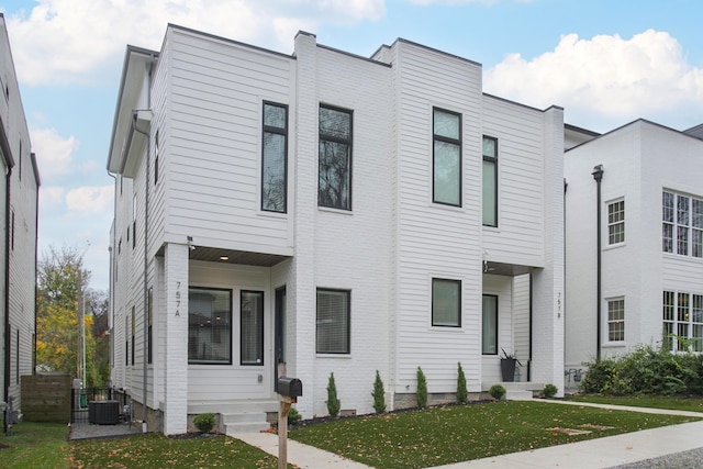 view of front of house featuring a front yard and central air condition unit