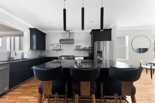 kitchen featuring sink, light hardwood / wood-style floors, tasteful backsplash, a kitchen island, and stainless steel appliances