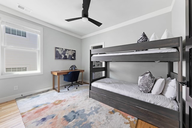 bedroom featuring ceiling fan, light wood-type flooring, and crown molding