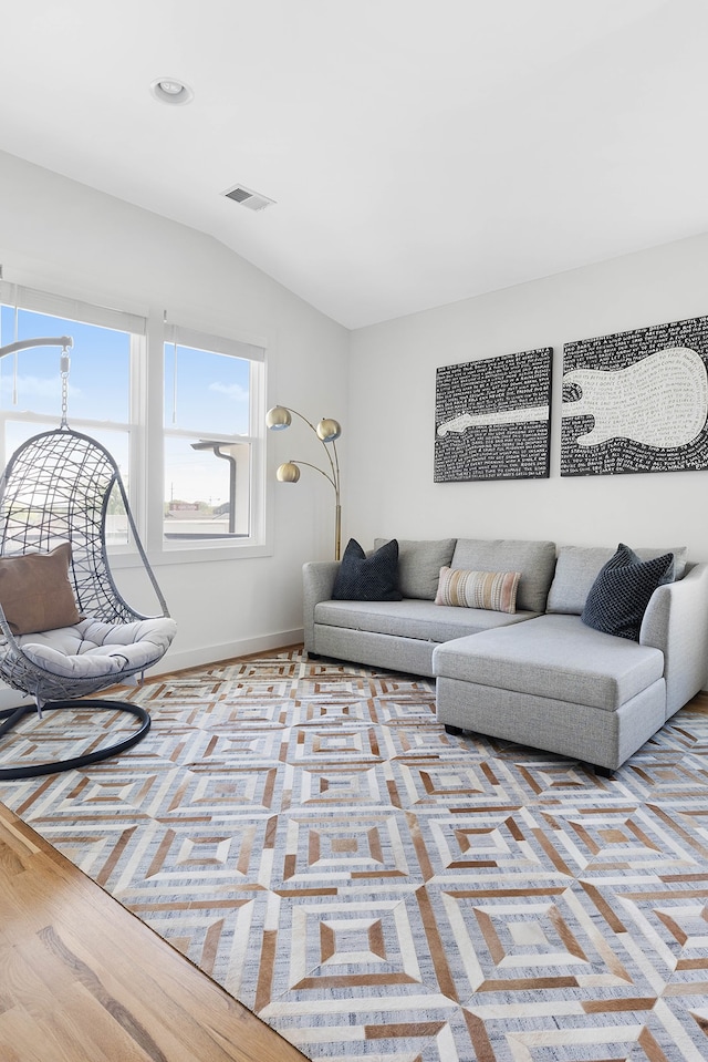 living room featuring light hardwood / wood-style flooring and vaulted ceiling