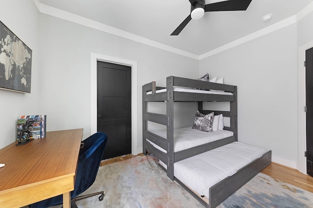 bedroom featuring ceiling fan, wood-type flooring, and ornamental molding