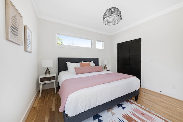 bedroom featuring crown molding and wood-type flooring