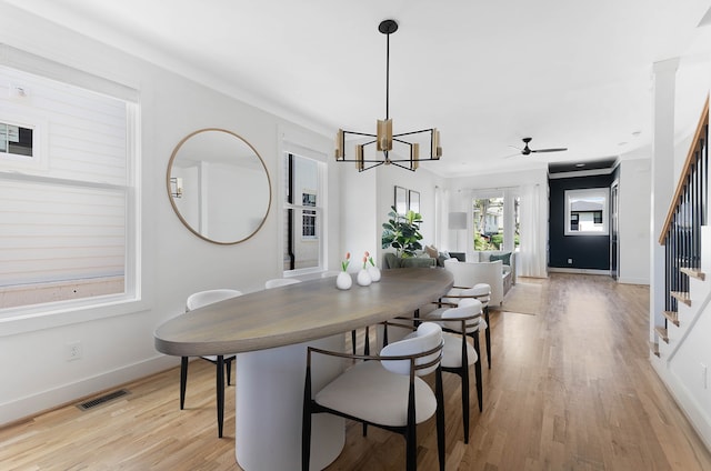 dining area featuring ceiling fan with notable chandelier and light hardwood / wood-style flooring