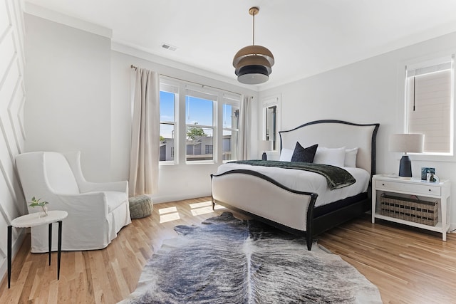 bedroom featuring hardwood / wood-style floors and crown molding