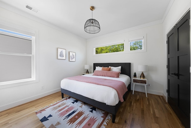 bedroom with wood-type flooring and ornamental molding