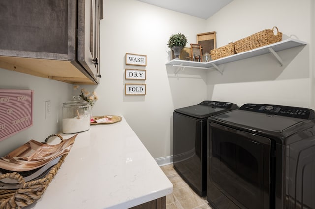 washroom featuring washer and clothes dryer, light tile patterned flooring, and cabinets