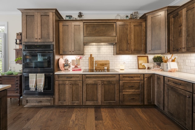 kitchen with custom exhaust hood, black appliances, dark hardwood / wood-style floors, decorative backsplash, and ornamental molding