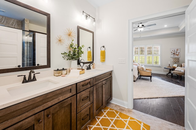 bathroom featuring vanity, a raised ceiling, hardwood / wood-style flooring, ceiling fan, and ornamental molding