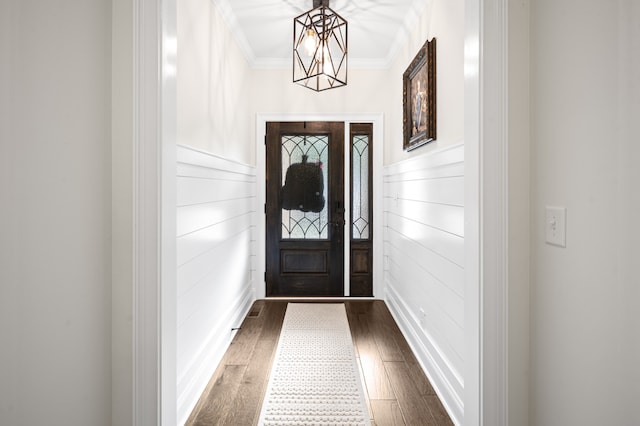 interior space featuring a chandelier, crown molding, and dark wood-type flooring