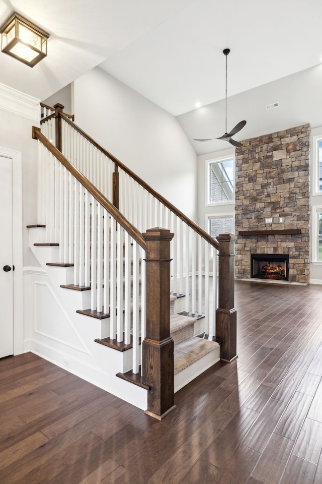 stairway with a fireplace and hardwood / wood-style floors