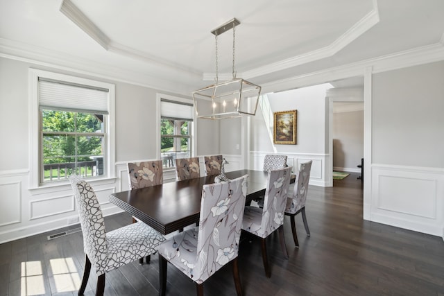 dining area featuring dark hardwood / wood-style floors, a raised ceiling, and crown molding