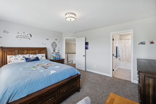 bedroom with ensuite bathroom and light colored carpet