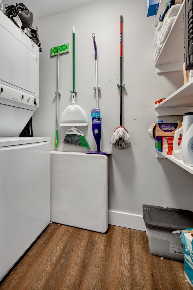 washroom featuring dark hardwood / wood-style flooring and stacked washing maching and dryer