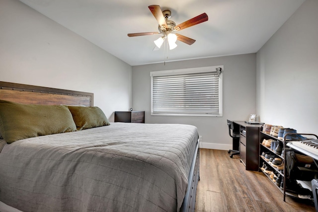 bedroom with ceiling fan, wood-type flooring, and vaulted ceiling