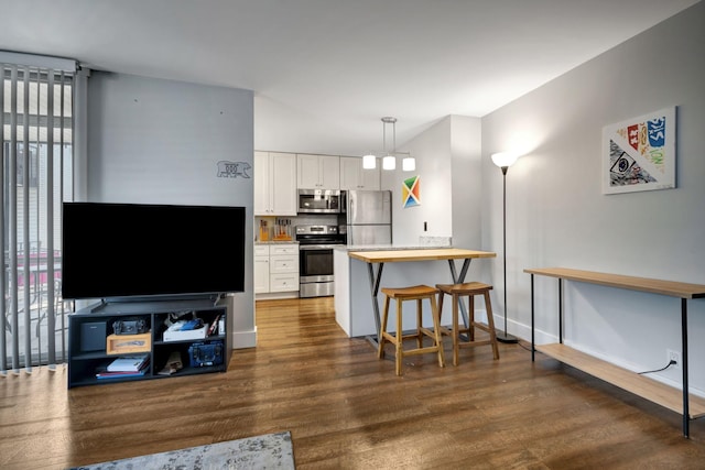 kitchen featuring kitchen peninsula, a healthy amount of sunlight, white cabinetry, and stainless steel appliances