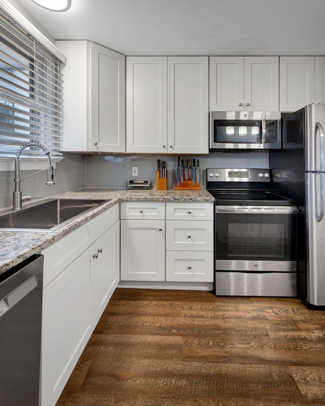 kitchen with white cabinetry, sink, stainless steel appliances, and dark hardwood / wood-style floors