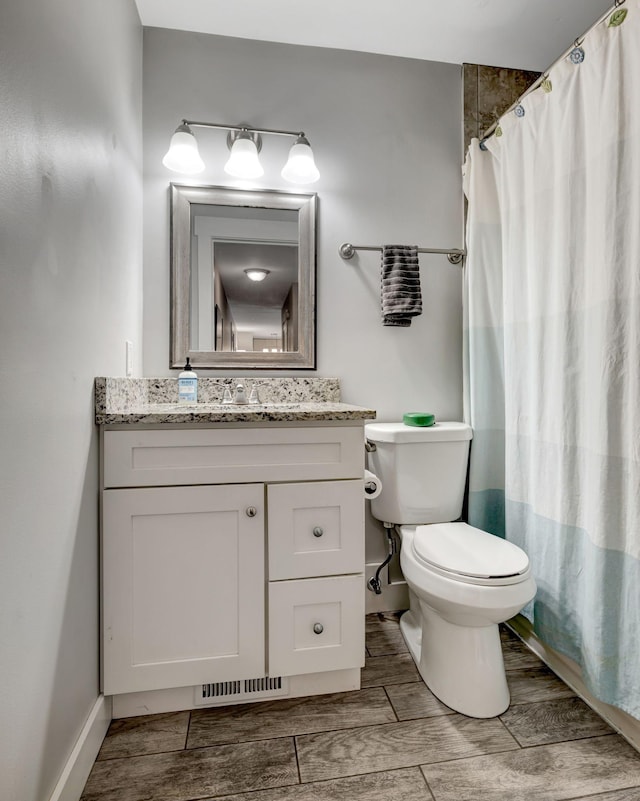 bathroom featuring curtained shower, vanity, wood-type flooring, and toilet