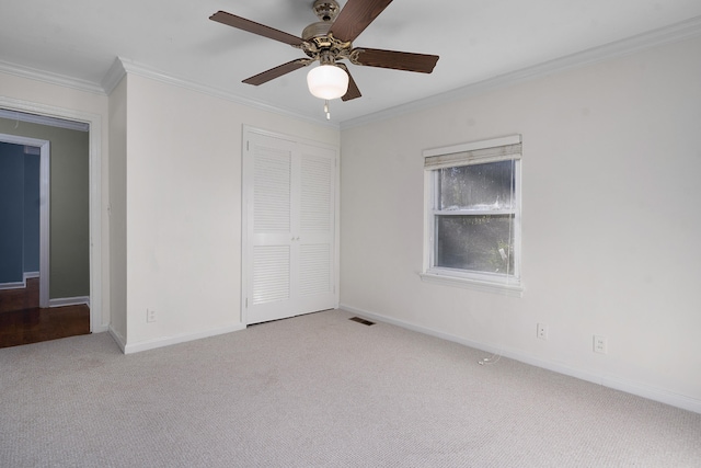 carpeted empty room featuring crown molding and ceiling fan