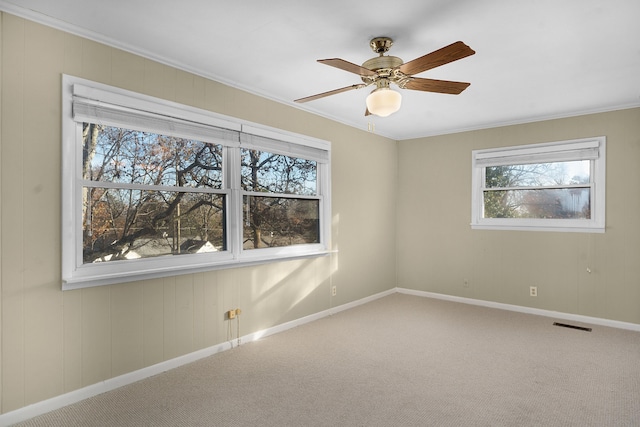 carpeted spare room with ceiling fan and crown molding