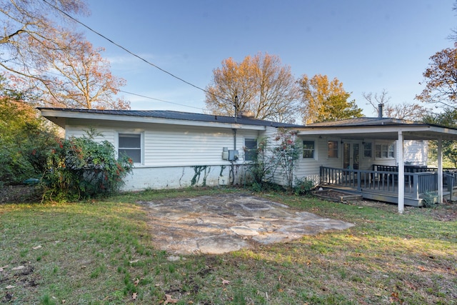 back of house with a wooden deck and a lawn