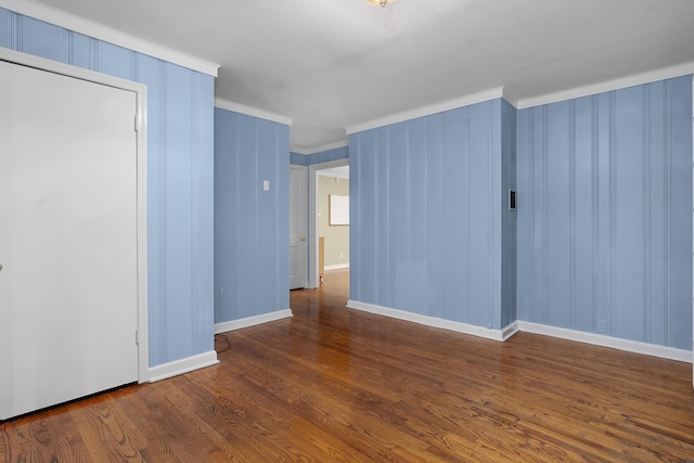 empty room featuring dark hardwood / wood-style floors and ornamental molding