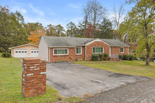 ranch-style house featuring an outbuilding, a garage, and a front lawn