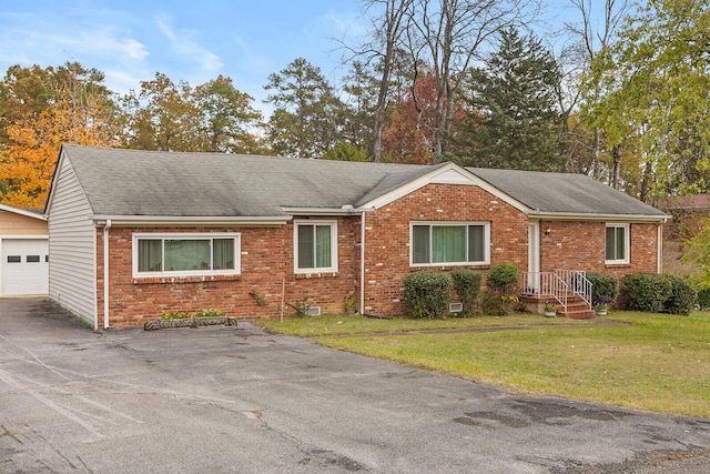 ranch-style house with a garage, an outbuilding, and a front lawn