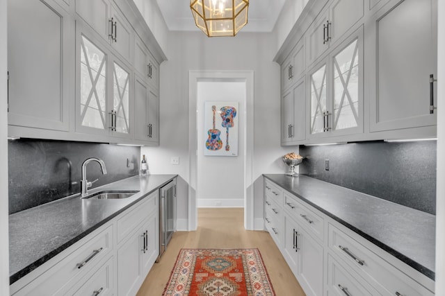 kitchen featuring white cabinets, light wood-type flooring, and sink