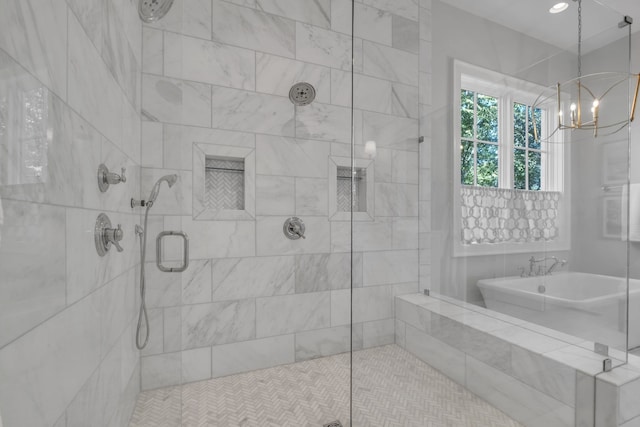 bathroom featuring separate shower and tub and a chandelier