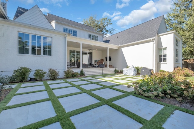 rear view of house with ceiling fan and a patio area