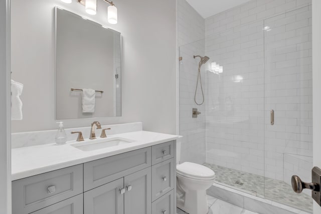 bathroom featuring vanity, toilet, and a shower with door