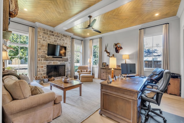 office space with a stone fireplace, ceiling fan, light hardwood / wood-style flooring, and wooden ceiling