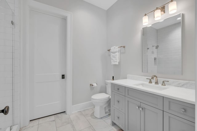 bathroom with tiled shower, vanity, and toilet