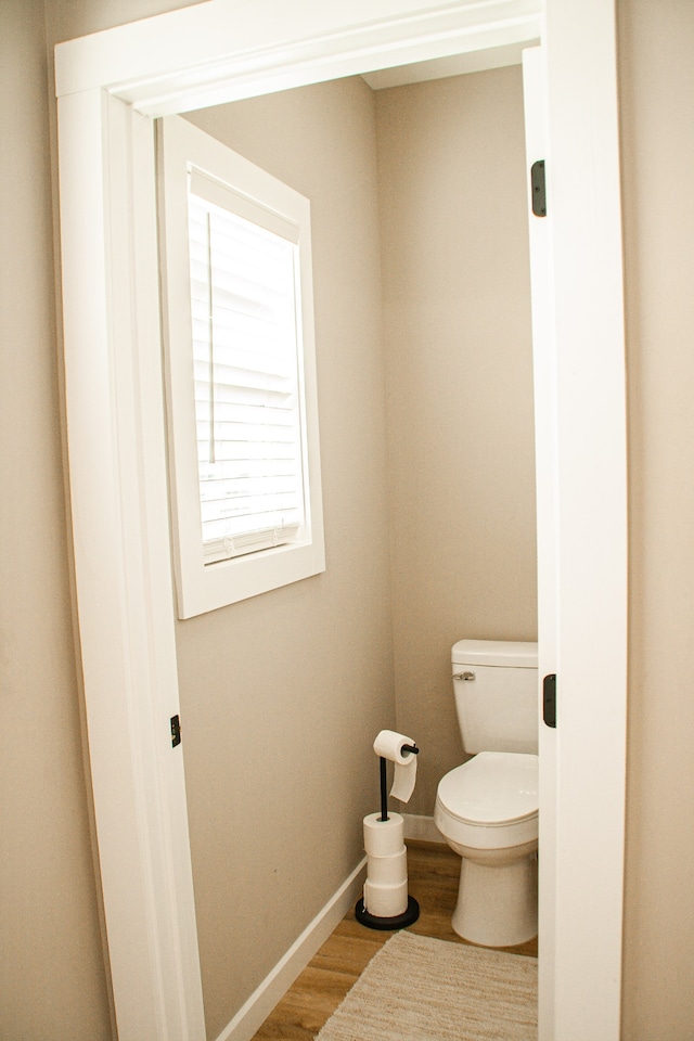 bathroom with toilet and hardwood / wood-style flooring