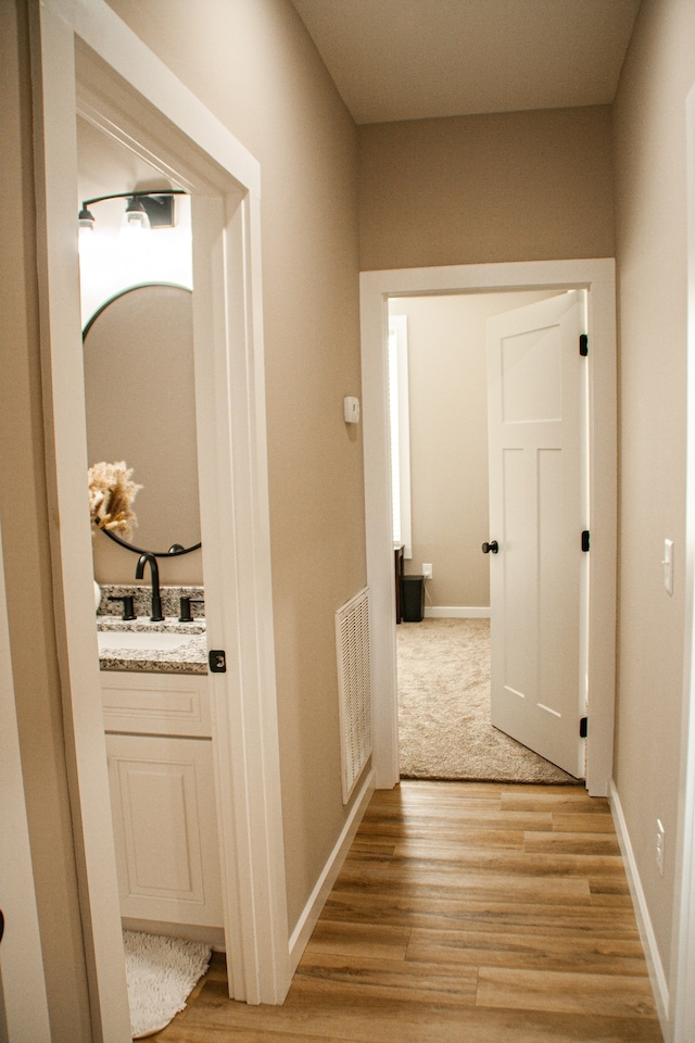 hall featuring light wood-type flooring and sink