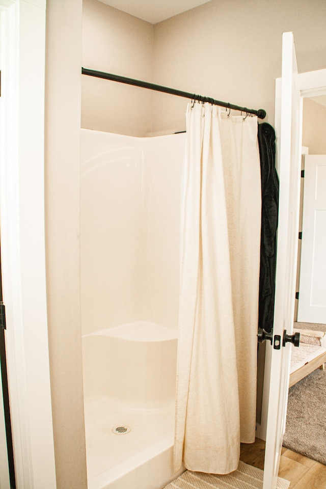 bathroom featuring curtained shower and wood-type flooring