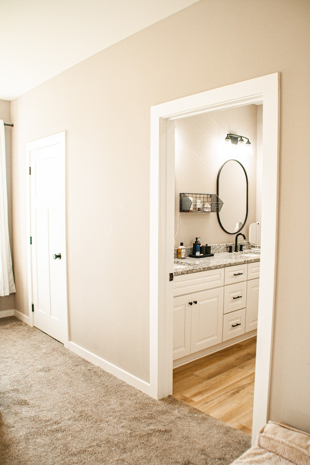 hallway featuring sink and light wood-type flooring