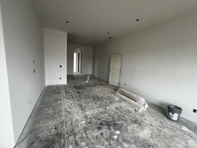 unfurnished living room with arched walkways