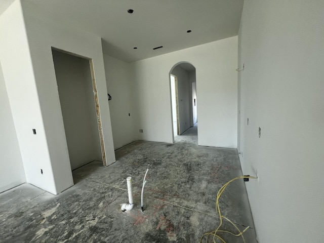 spare room featuring arched walkways