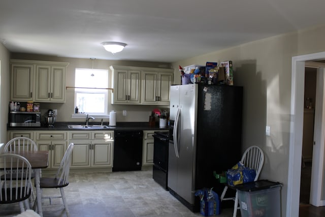 kitchen with sink, black appliances, and cream cabinetry